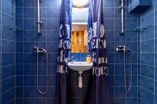 a bathroom with blue tiled walls and a sink at Chata Horec in Štrba