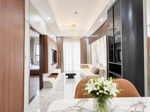 a living room with a vase of flowers on a table at Cara Riverside Cần Thơ- 2 mins GO Cần Thơ in Can Tho