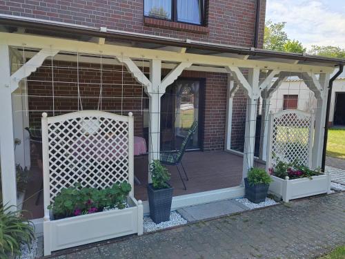 a pergola on a house with flowers and plants at Rügen Fewo 303 in Gingst