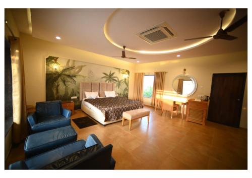 a bedroom with a bed and a couch and a chair at Dream Habitat Resort in Mohurli
