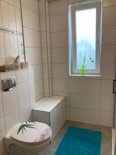 a bathroom with a toilet and a window at Ferienwohnung Keull in Coesfeld
