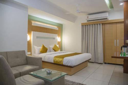 a hotel room with a bed and a couch at Hotel Orange International in Surat