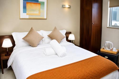 a bedroom with a large bed with white sheets and pillows at AC Hotel in Luanda