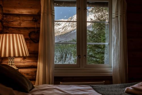 a bedroom with a window with a mountain view at Phillipshaugen Lodge in Øksendalsøra