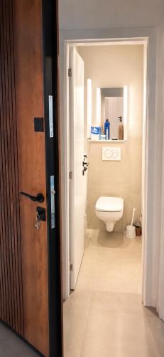 a bathroom with a white toilet and a door at Cozy aparment Susanj,Bar in Bar