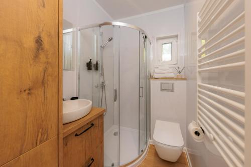 a bathroom with a shower and a sink and a toilet at Hygge Tiny House 2 - Berlin Brandenburg in Berlin