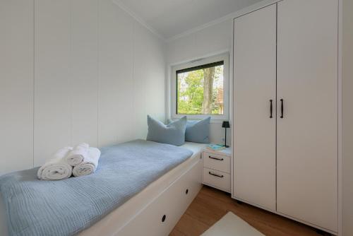 a small bedroom with a bed and a window at Hygge Tiny House 2 - Berlin Brandenburg in Berlin