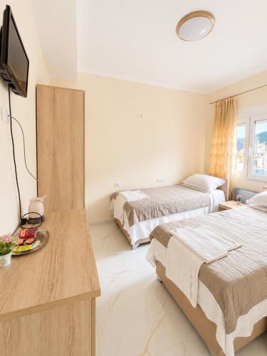 a hotel room with two beds and a flat screen tv at R&A Apartments in Berat