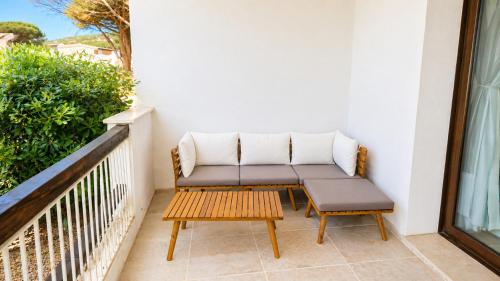 a couch and a table on a balcony at Rena Bianca Residence 201 in Baja Sardinia