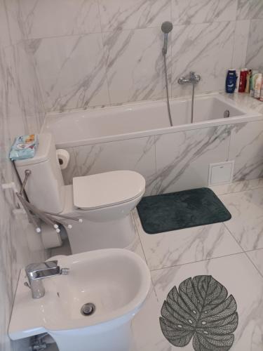 a bathroom with a toilet and a sink and a tub at Kamienica Senator in Skierniewice