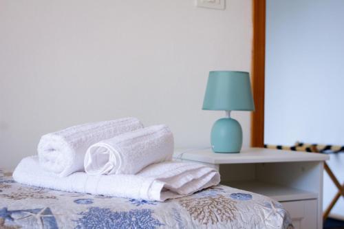 a pile of towels sitting on top of a bed at VILLA FRANCA in Fontane Bianche