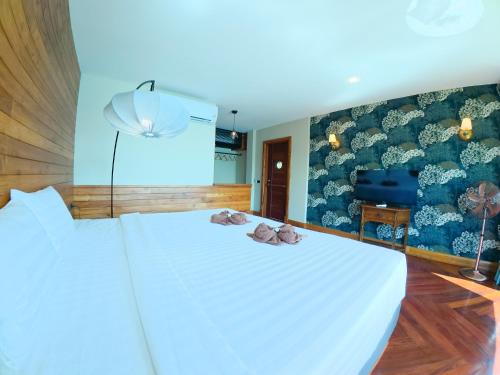 a bedroom with a white bed and a blue wall at Salty Pearl Beach Front Phuket 3 in Patong Beach