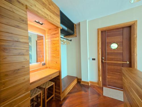 a bathroom with wooden walls and a wooden door at Salty Pearl Beach Front Phuket 3 in Patong Beach