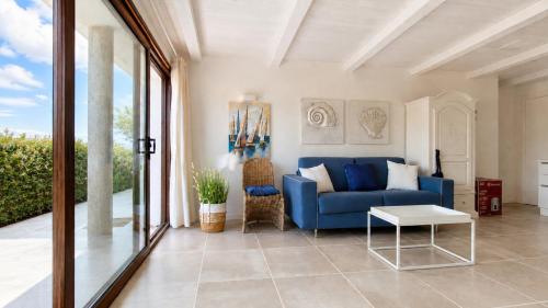 a living room with a blue couch and a table at Rena Bianca Residence 241 in Arzachena