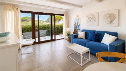 a living room with a blue couch and a table at Rena Bianca Residence 241 in Arzachena