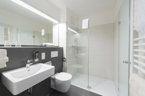 uma casa de banho com um lavatório, um WC e um chuveiro em Hotel Restaurant Bären em Isny im Allgäu