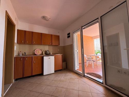 a kitchen with wooden cabinets and a white refrigerator at SS Pearl Apartment in Utjeha