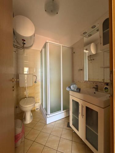 a bathroom with a toilet and a sink and a shower at SS Pearl Apartment in Utjeha