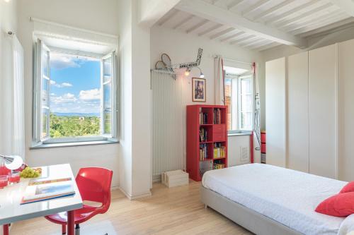 a bedroom with a bed and a desk and a window at ANTICA VILLA MERELLI 12, Emma Villas in Monte San Savino