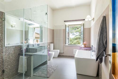 a bathroom with a sink and a tub and a toilet at ANTICA VILLA MERELLI 12, Emma Villas in Monte San Savino