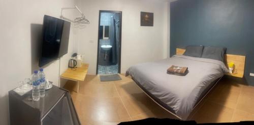 a bedroom with a bed and a flat screen tv at Baan Suan Papa Resort Wangmuang in Ban Nong Lom (1)