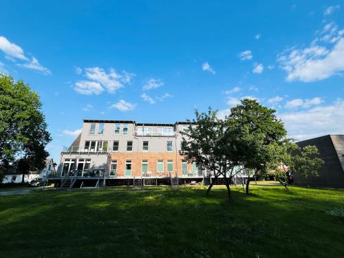 a building with a tree in the middle of a field at Gutshaus Wohnung 6 in Laschendorf