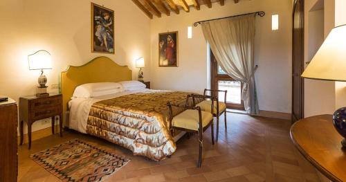 a bedroom with a bed and a table and a desk at Borgo Storico Seghetti Panichi in Castel di Lama