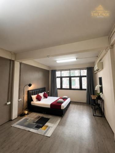 a bedroom with a bed with red pillows at The Cage Suites in Bangkok