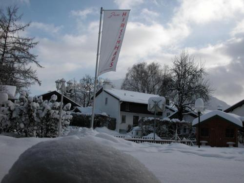 a sign in the snow in front of a building at Hotel-Restaurant Zum Hirschhaus Inklusiv Chiemgaukarte in Ruhpolding