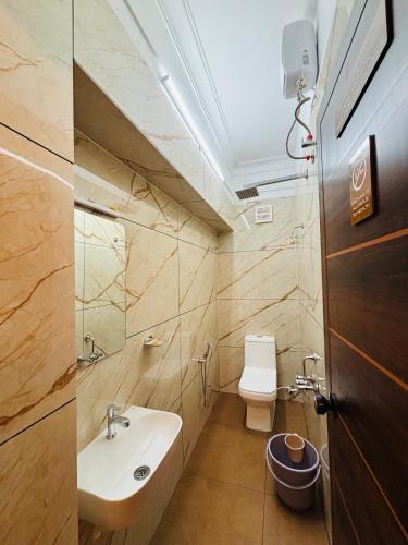 a bathroom with a sink and a toilet at Fort Grande ONE in Cochin