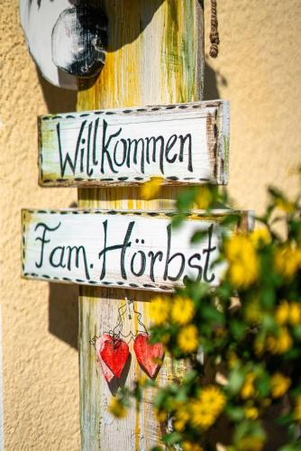a sign for a farm house with hearts on it at Ferienwohnung Sonnenbichl in Schattwald