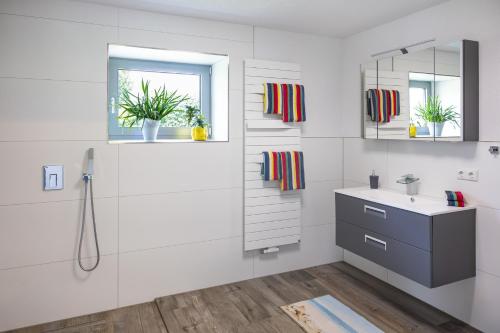 a white bathroom with a sink and a mirror at Spatzenhuus in Rubkow
