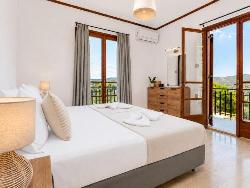 a bedroom with a white bed and a balcony at Villa Apelati in Keri