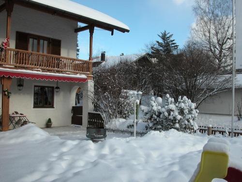 a yard covered in snow next to a house at Hotel-Restaurant Zum Hirschhaus Inklusiv Chiemgaukarte in Ruhpolding