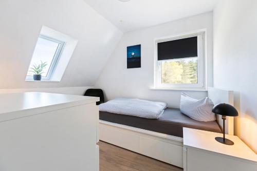 a small bedroom with a bed and two windows at Appartementanlage Wieben in Böhl