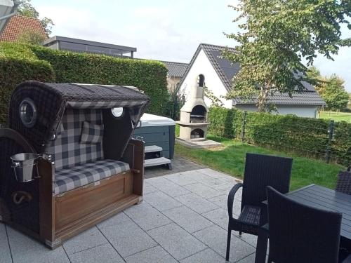 a patio with a chair and a table and a church at Villa Sole am Fleesensee in Göhren-Lebbin