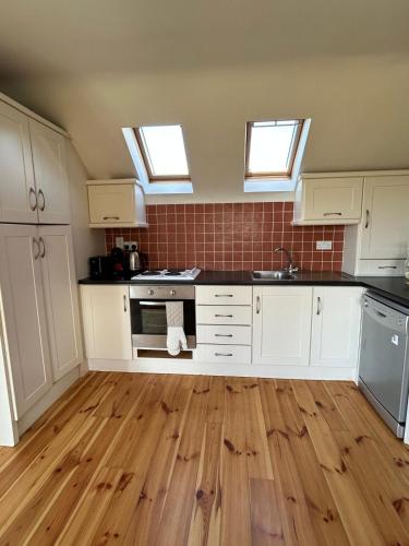 a kitchen with white cabinets and two skylights at Fanore Apartment 1 in Fanore