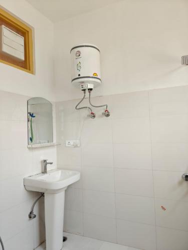 a white bathroom with a sink and a mirror at The Apricot Palace in Kargil