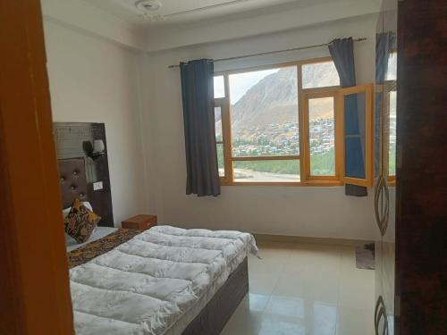a bedroom with a large bed and a window at The Apricot Palace in Kargil