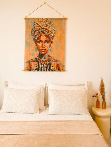 a painting of a woman on the wall above a bed at Acheron House in Gliki