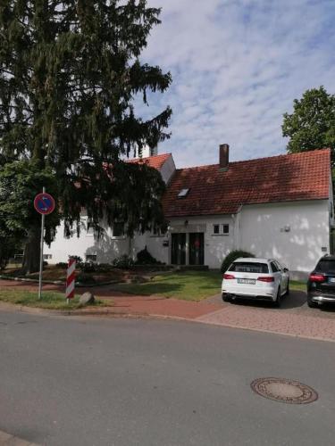 a white house with two cars parked in front of it at FeWo Atlanta in Reinhardshausen