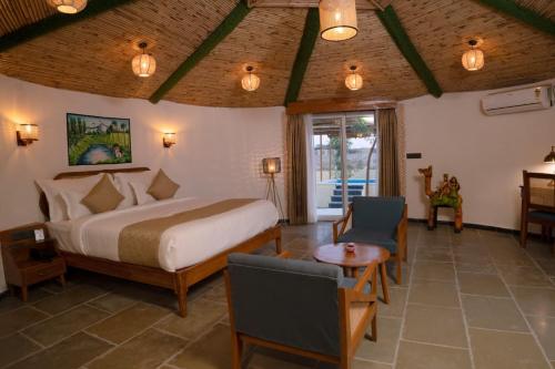 a bedroom with a bed and a table and a chair at Yadus By Alcor in Bīsalpur