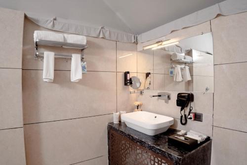 a bathroom with a sink and a phone on the wall at Yadus By Alcor in Bīsalpur