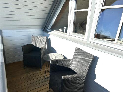 two chairs and a table on a porch with a window at Ferienhaus HarzHase in Harzgerode