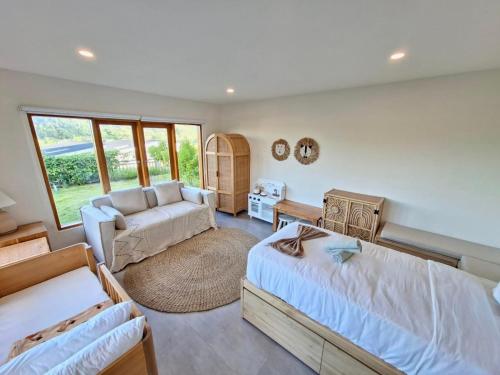 a bedroom with two beds and a couch at Villa August Lombok in Selong Belanak