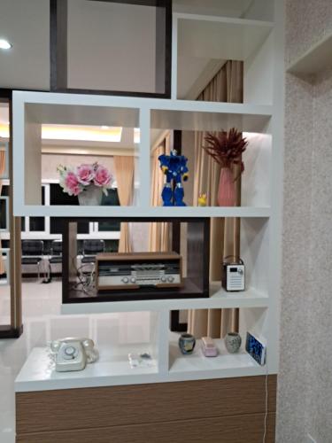 a room with a shelf with flowers and vases at Minie House Hatyai in Hat Yai