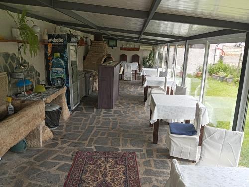 a restaurant with tables and white tables and chairs at Villa Savovi in Varna City