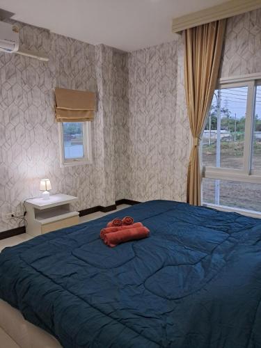 a bedroom with a blue bed with two red towels on it at Minie House Hatyai in Hat Yai