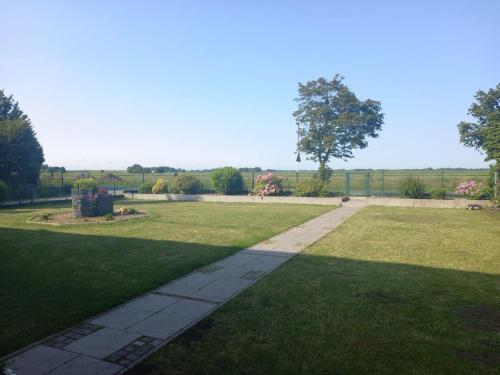 a park with a walkway in the grass at Ferienwohnung Landliebe in Süderschweiburg