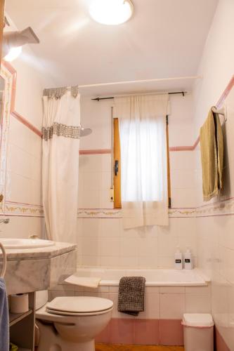 a bathroom with a toilet and a tub and a sink at La Casa del Carrebaix in Orba